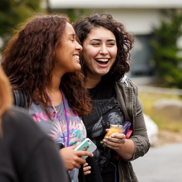 two potential students on a tour laughing and with one another